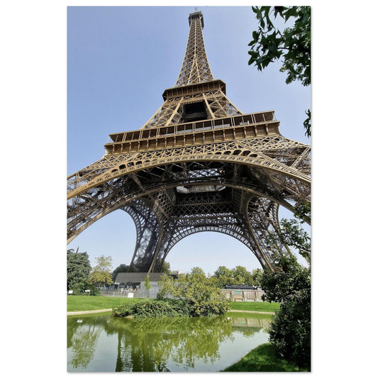 Vue en contre-plongée de la Tour Eiffel depuis les jardins du Champ-de-Mars avec reflet dans l'eau d'un bassin - Photographie d'art Kellestom.