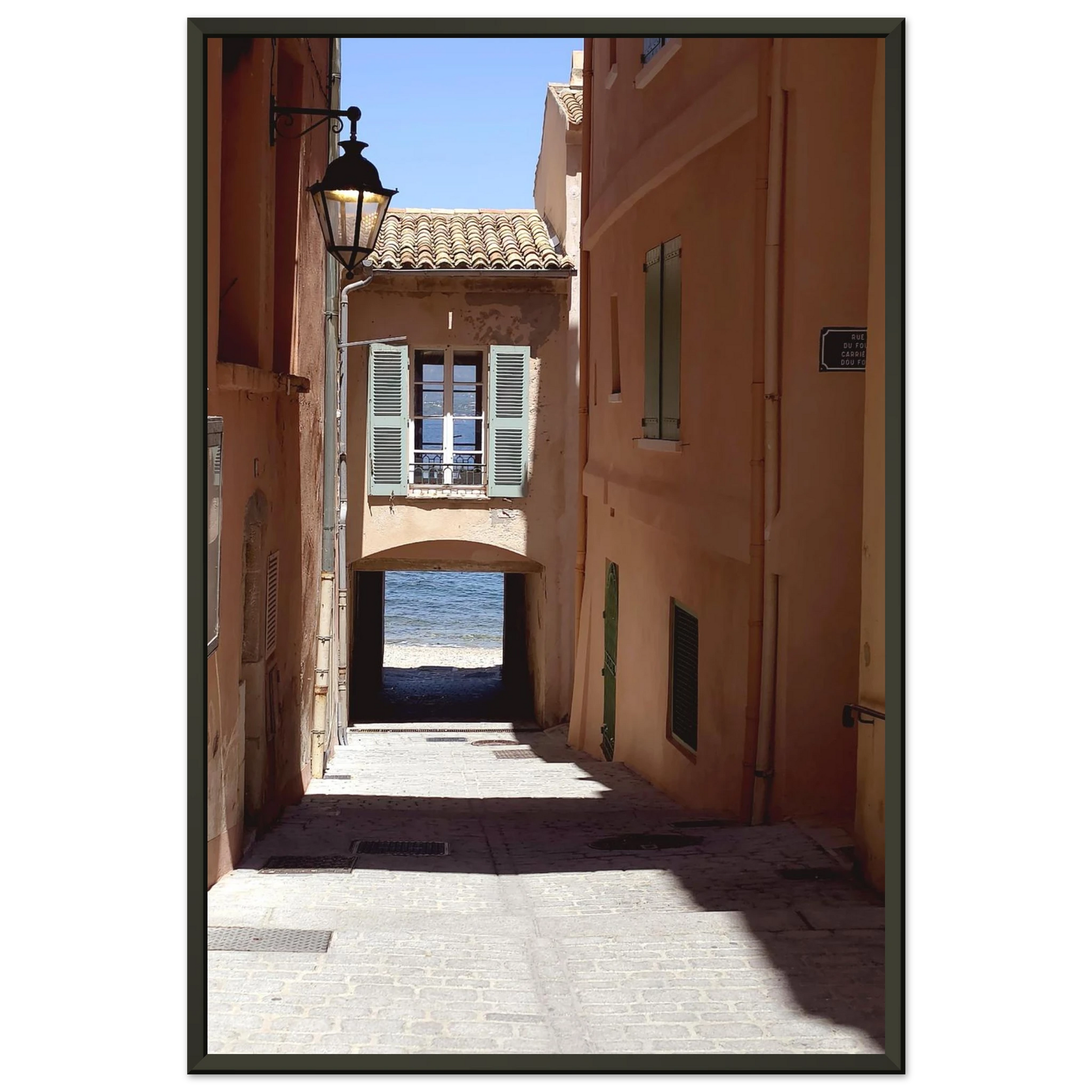 Photo d'art d'une ruelle ombragée à Saint-Tropez menant vers la mer Méditerranée avec architecture provençale