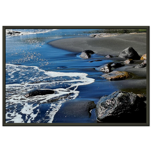 Photographie d'art d'une plage de sable noir volcanique avec écume de mer blanche et rochers humides, format 30x45 cm | Kellestom